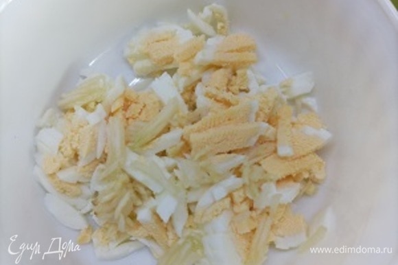 Отварные яйца очистить и мелко нарубить, добавить нарубленный чеснок.