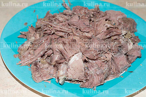Когда мясо будет готово, вытащить его из бульона вместе с овощами и нарезать на кусочки.