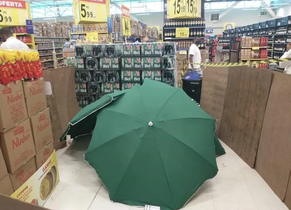 Когда сотрудник магазина умер, его прикрыли зонтами и продолжили работать