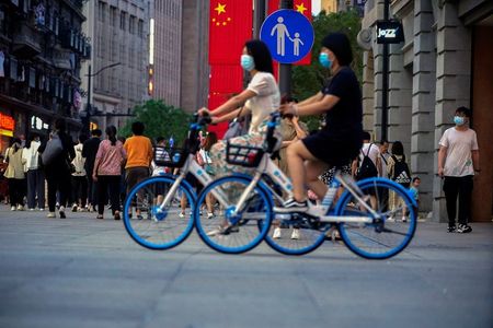 Woman ride bikes on a street, following the outbreak of the coronavirus disease (COVID-19), in Shanghai, China May 10, 2021. REUTERS/Aly Song