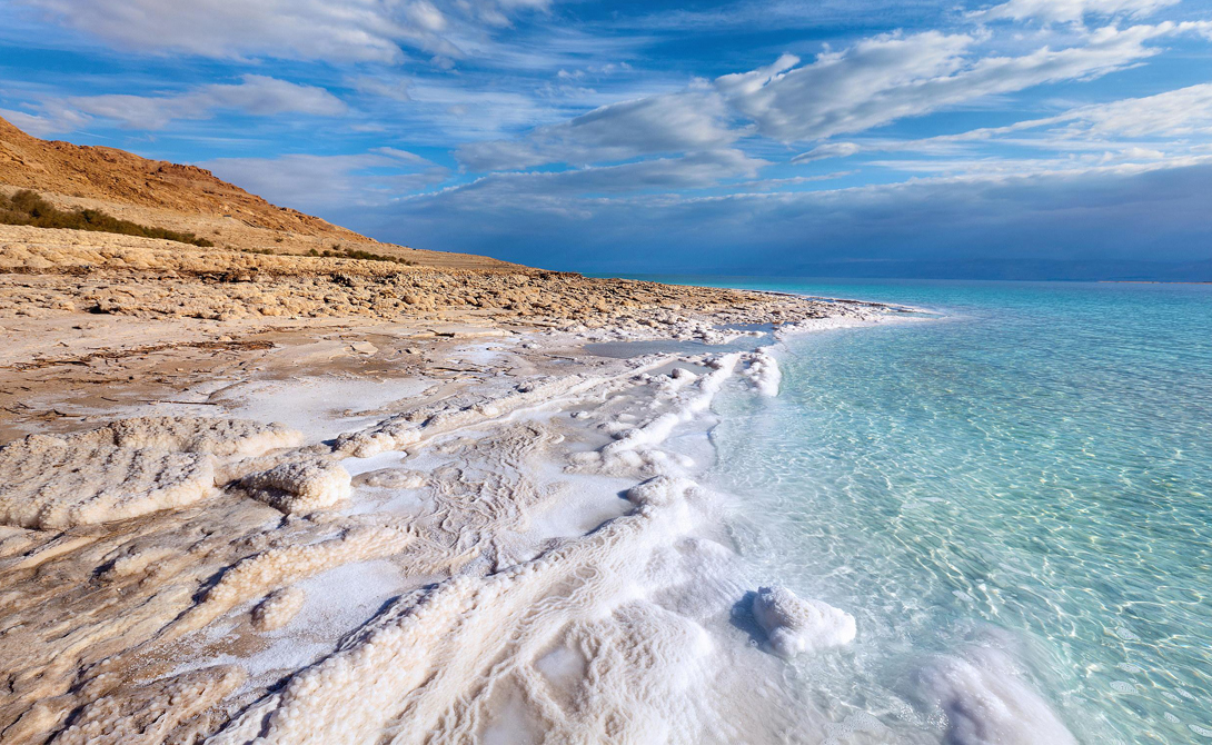 Мертвое море Израиль Обилие растворенных в воде минералов уничтожает любые попавшие сюда микроорганизмы. Прибрежные скалы озера переливаются кристаллизованным хлоридом натрия: здесь Солнце испаряет воду, украшая берега затейливым фрактальным узором. Это самое глубокое в мире (330 метров) гиперминерализованное озеро. В последние годы размеры водоема значительно сократились, но израильские геологи считают, что вскоре ситуация стабилизируется.