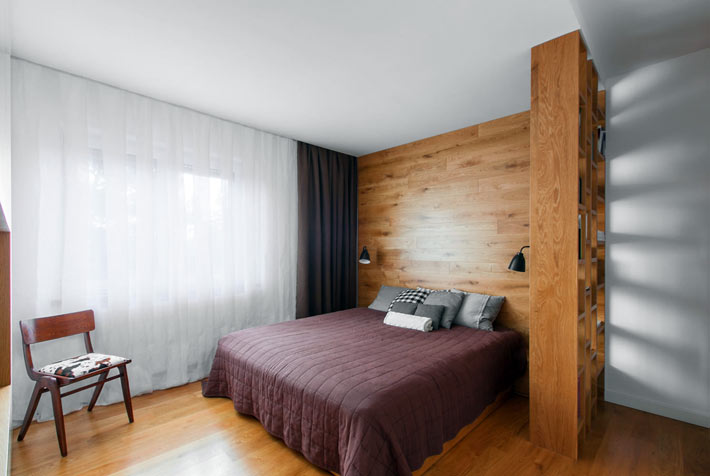 Стена в спальне возле изголовья кровати обшита натуральным деревом фото