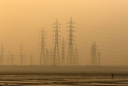 A worker levels a salt pan near electricity pylons in Mumbai, India, January 16, 2017. REUTERS/Shailesh Andrade A worker levels a salt pan near electricity pylons in Mumbai, India, January 16, 2017. REUTERS/Shailesh Andrade