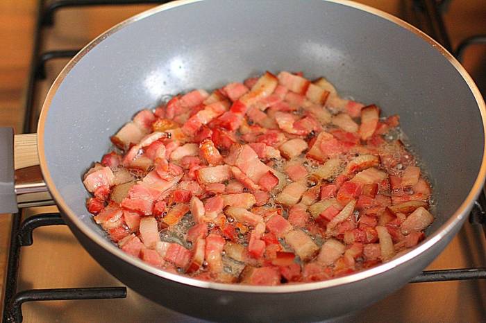 На сухой сковороде обжарить грудинку.