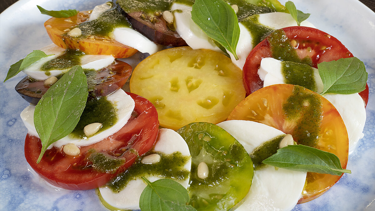 Яркий, вкусный и очень простой салат Капрезе - понравится абсолютно всем!   Сочетание спелых и сочных томатов с нежной моцареллой дополнит незабываемый вкус ароматное песто.