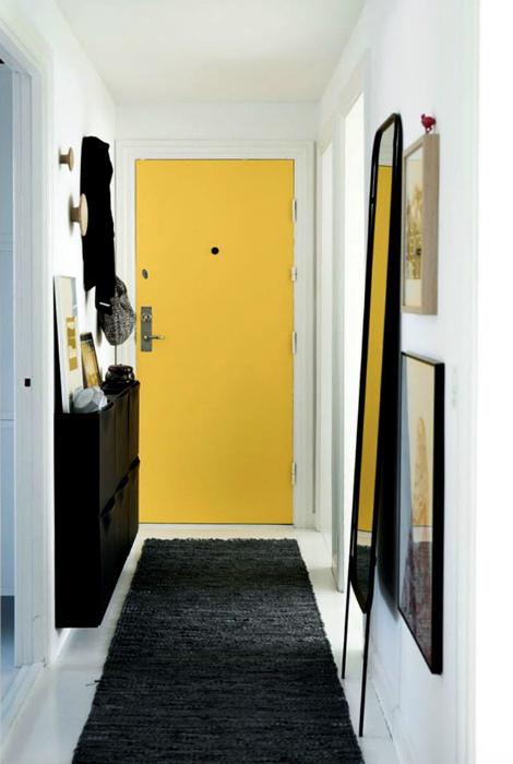Прихожая со светлыми стенами и желтой дверью.