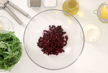 Фото приготовления рецепта: Салат из красной фасоли с творожным сыром, красным луком и сезонным салатом - шаг 1