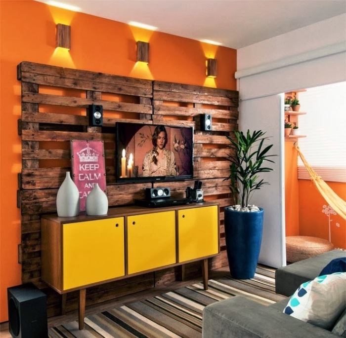 Стена из деревянных поддонов как основной акцент гостиной комнаты - это оригинальный вариант оформления интерьера и на первый взгляд может показаться, что телевизору совсем не место возле этой стены.