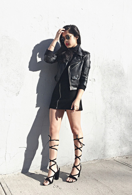 Модель в черном мини платье, куртке косухе и босоножки на шнуровке