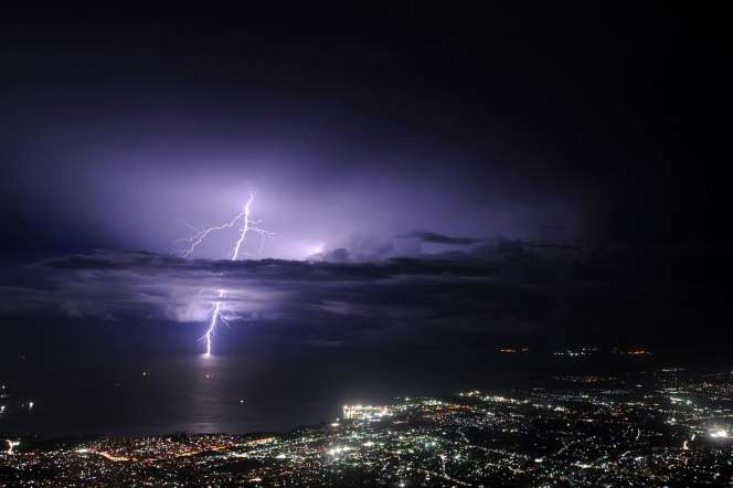 Lightning strikes over the sea along the coast of the Haitian capital, Port au Prince,  during an evening thunderstorm on September 24, 2014.