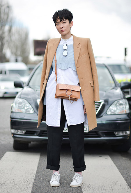 Модель с черных брюках, длинная рубашка и бежевое пальто