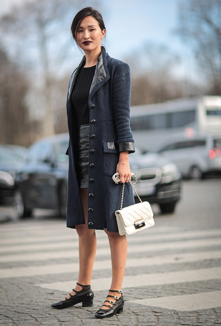 Девушка в мини юбке, топ и серое пальто на пуговицах, белая сумочка