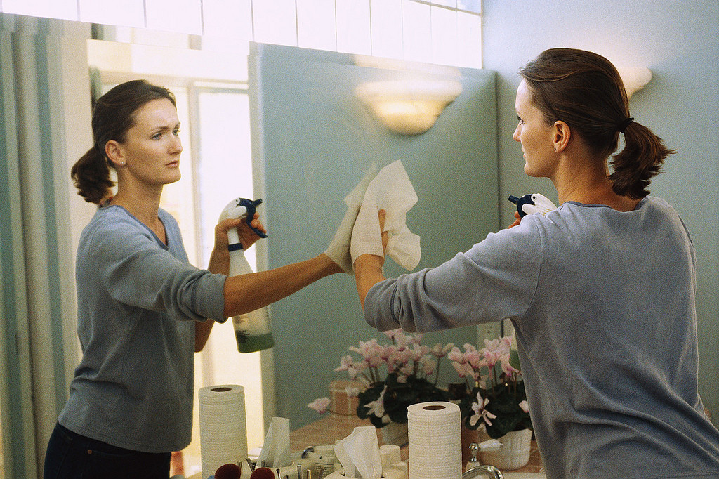 Woman cleaning mirror