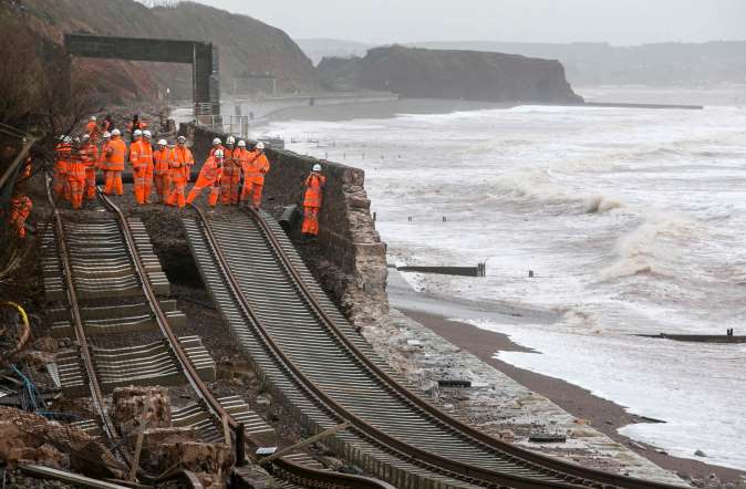Railway workers inspect the main Exeter to Plymouth railway line that has been closed due to parts of it being washed away by the sea at Dawlish on February 5, 2014.