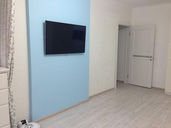 Телевизор на стене в гостиной, белые двери в интерьере