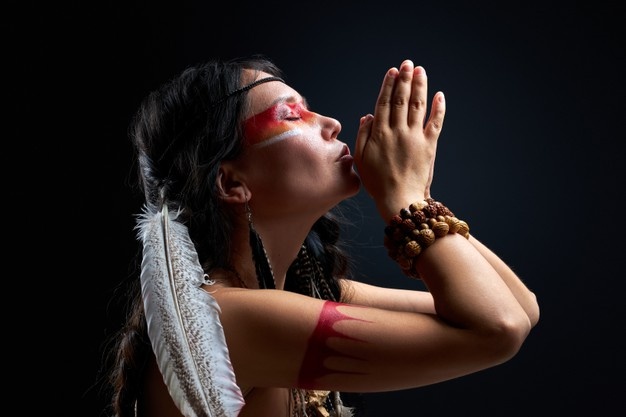 Черный племенной мужчина шаман указывая пальцем в сторону, указатель,  показывая что-то, изолированные на черной стене | Премиум Фото