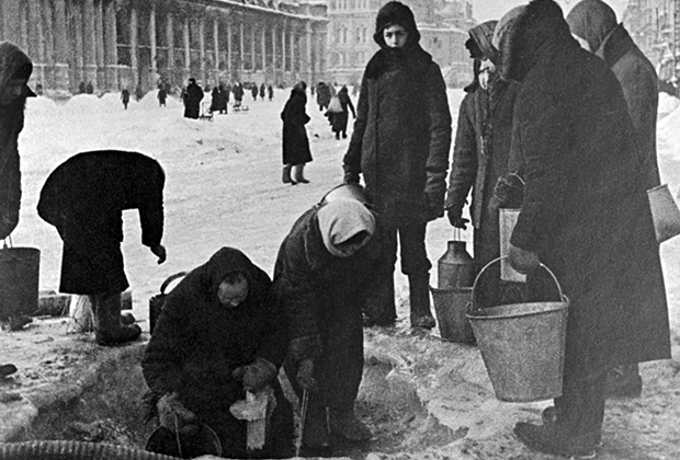 Жители блокадного Ленинграда набирают воду, появившуюся после артобстрела в пробоинах в асфальте на Невском проспекте.