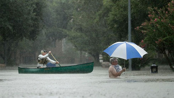 People Evacuate A Neighborhood Inundated By Floodwaters From Tropical Storm Harvey On Monday