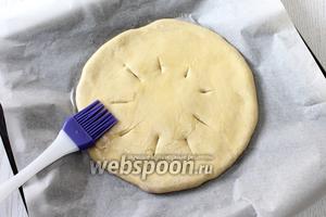 Перенести лепёшку на противень, застеленный бумагой для выпечки. Смазать взбитым яйцом, сделать проколы или маленькие надрезы для выхода пара.