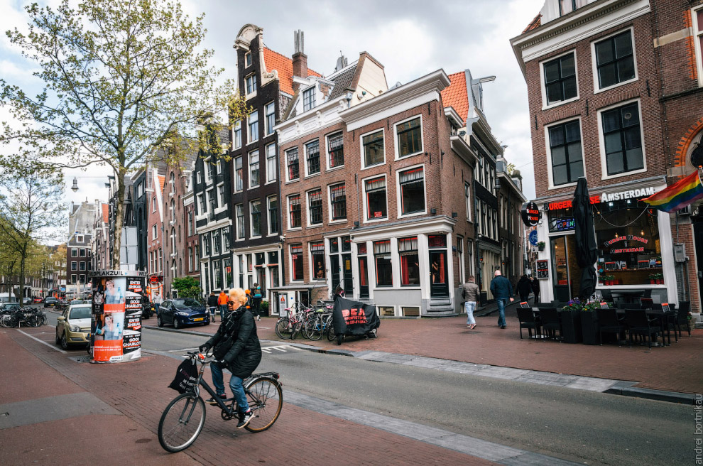 Adult woman rides a bicycle in red light district of Amsterdam, Netherlands