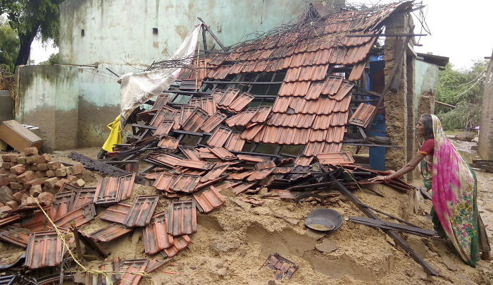 An Indian Woman Stands Outside Her Damaged House In Runi Village In Gujarat