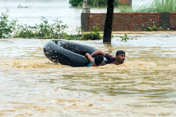 Nepalis Swim With A Rubber Ring In A Flooded Area In Parsa District