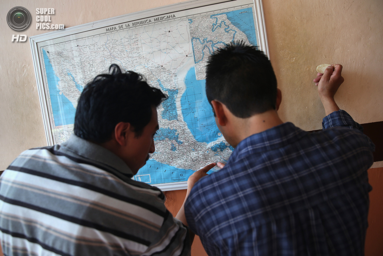 Мексика. Арриага, Чьяпас. 3 августа. Иммигранты рассматривают карту Мексики перед посадкой на грузовой поезд. (John Moore/Getty Images)