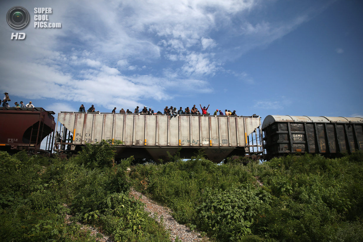 Мексика. Сьюдад-Истепек, Оахака. 4 августа. Гватемальские нелегальные иммигранты верхом на грузовом поезде, направляющемся на север. (John Moore/Getty Images)