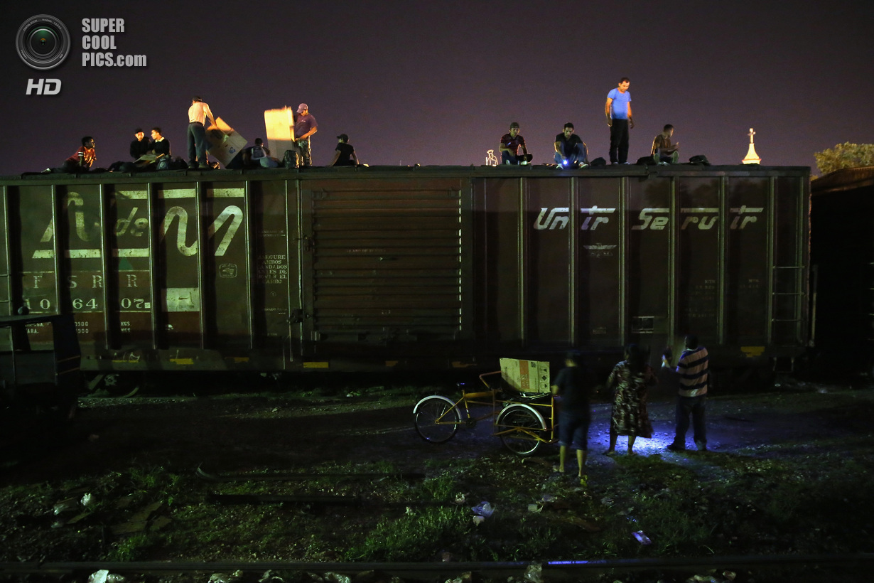 Мексика. Арриага, Чьяпас. 4 августа. Гватемальские нелегальные иммигранты верхом на грузовом поезде, направляющемся на север, во время грозы. (John Moore/Getty Images)