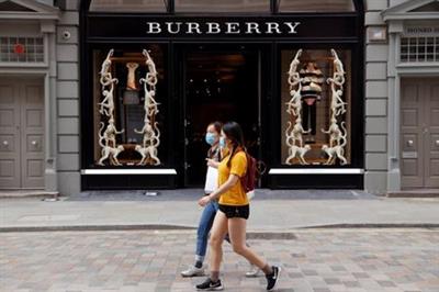 FILE PHOTO: People wearing protective masks walk past a Burberry store at Covent Garden, following the outbreak of the coronavirus disease (COVID-19) in London, Britain June 15, 2020. REUTERS/John Sibley