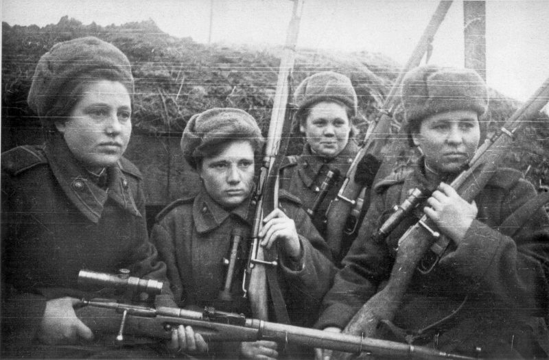 Неизвестные советские девушки-снайперы у блиндажа. На шинелях сержантские погоны, в руках винтовки Мосина с оптическим прицелом ПУ (Прицел Укороченный). Фотохроника газеты «Известия» 1944 года.