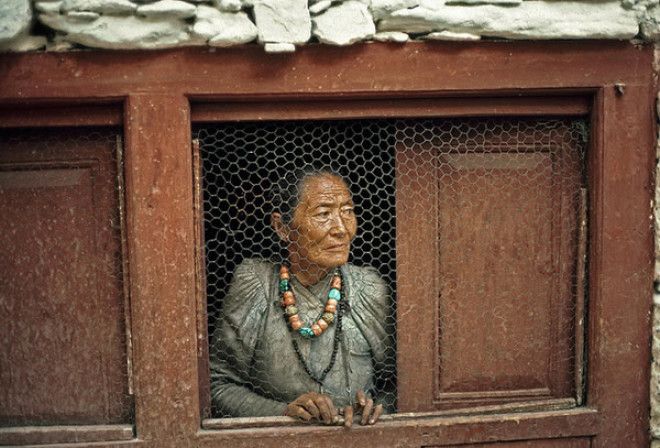 Женщина у окна в непальской деревне