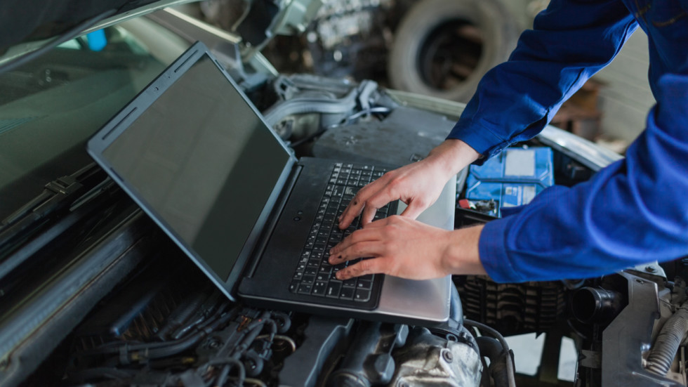 Close-up of auto mechanic using laptop