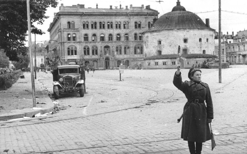 Советская регулировщица на улице освобожденного Выборга. Выборг, Ленинградская область. Время съемки: 21.06.1944. Автор: Григорий Чертов. Источник: vbgcity.ru.