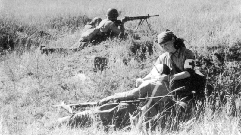 Медсестра В. Смирнова на поле боя оказывает помощь раненому бойцу. 1942. Сталинград, район хутора Вертячий
