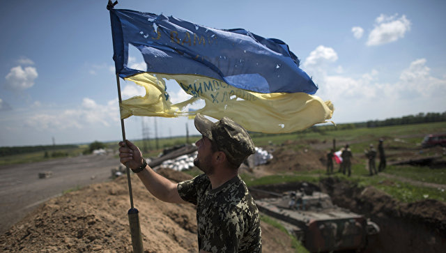 Украинский военный устанавливает флаг Украины в Марьинке недалеко от Донецка. Архивное фото Украинский военный устанавливает флаг Украины в Марьинке недалеко от Донецка. Архивное фото
