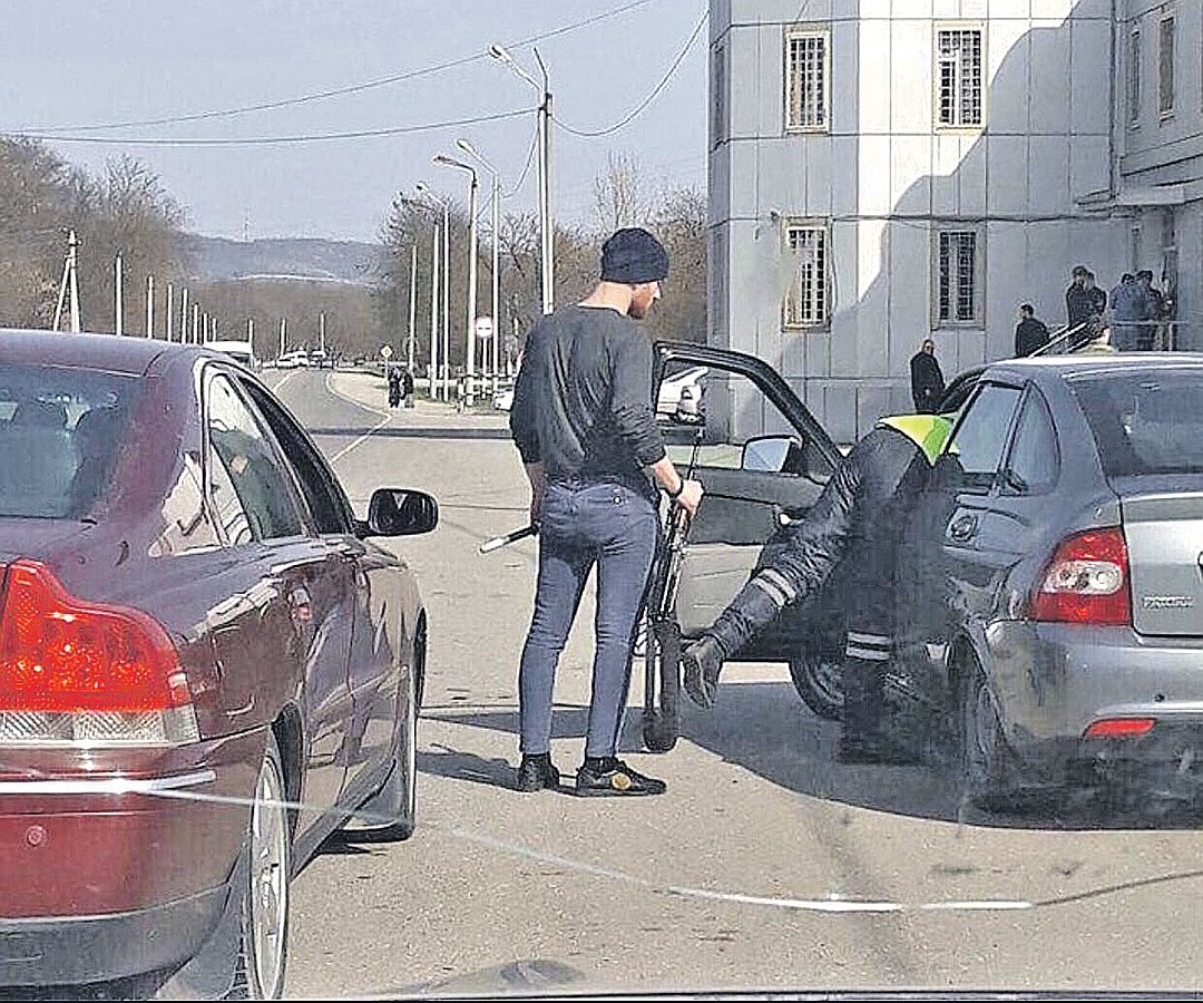Этот шедевральный кадр разлетелся по соцсетям в начале весны. Инспектор осматривает машину, дав подержать водителю свои жезл и калаш. По-братски, по-кавказски! Фото: youtube.com