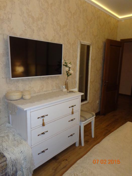 Изящная спальня, телевизор в спальне, белый комод и зеркало в спальне