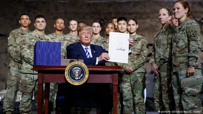 Дональд Трамп на церемонии на военной базе в Форте Драм демонстрирует подписанный закон об оборонном бюджете на 2019 год Дональд Трамп на церемонии на военной базе в Форте Драм демонстрирует подписанный закон об оборонном бюджете на 2019 год