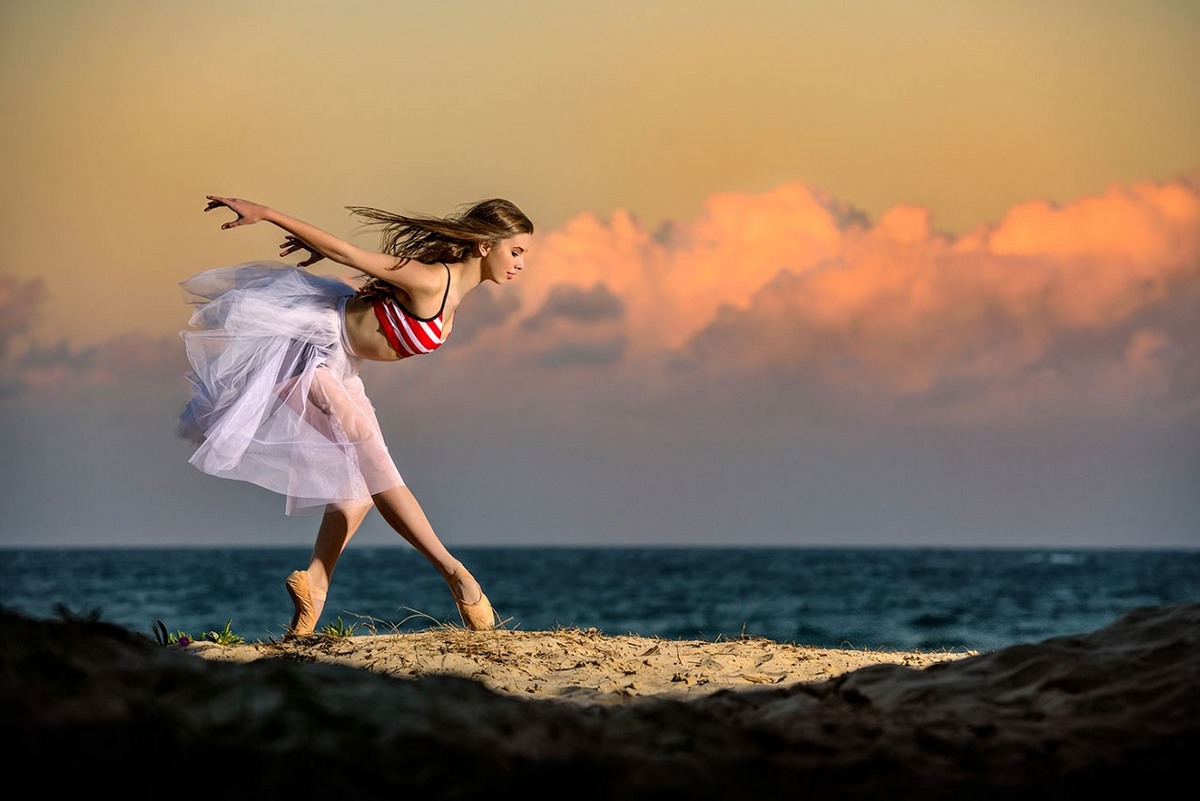 Девушка танцует на берегу моря