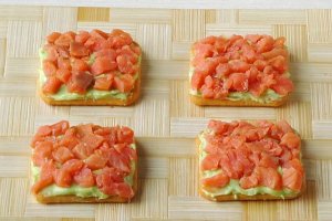 Поверх пасты уложить кусочки рыбы.