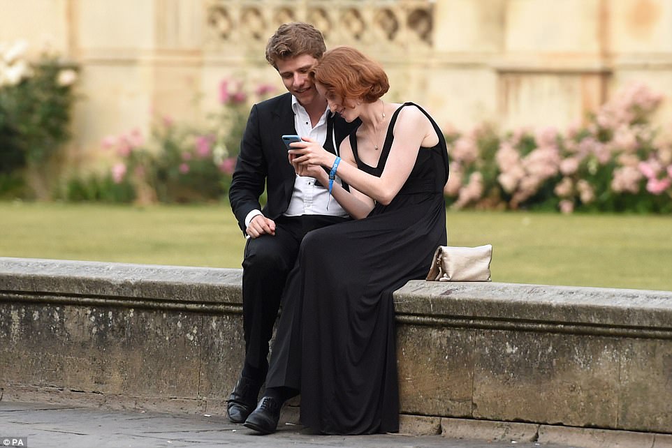 A couple look at snaps from the May Ball, which is steeped in tradition and last year celebrated its 150th installment