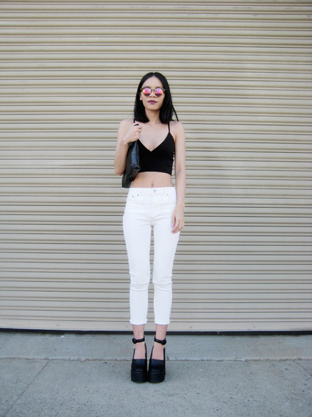 Модель в белых капри, черный кроп топ и туфли на платформе