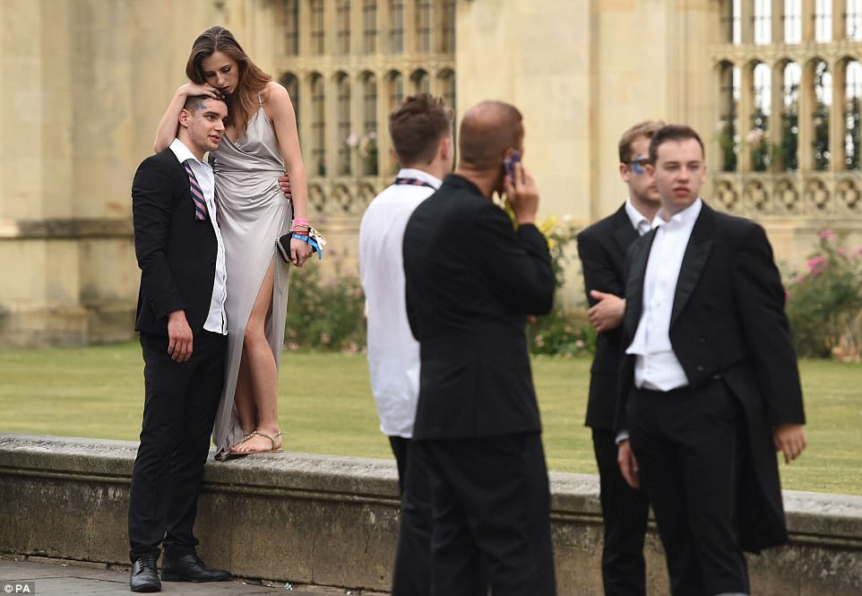 One exhausted party-goer leans on a male friend's head for support after celebrating until the early hours of Tuesday morning