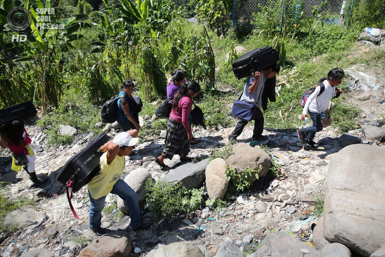 Мексика. Талисман, Чьяпас. 1 августа. Группа гватемальских нелегальных иммигрантов с багажом идут по направлению к железной дороге. (John Moore/Getty Images)