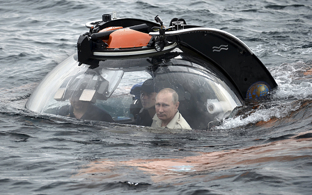 Russian President Vladimir Putin (R) looks through a window of a research bathyscaphe while submerging into the waters of the Black Sea as he takes part in an expedition near Sevastopol, Crimea