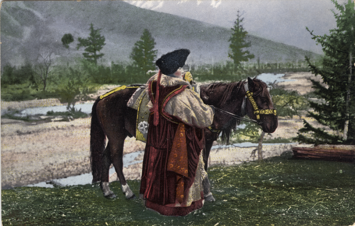Женщина алтайка стоит возле лошади в куараан борук (головной убор), тон (шуба из овчины) и чегедек (безрукавке). Женщина алтайка стоит возле лошади в куараан борук (головной убор), тон (шуба из овчины) и чегедек (безрукавке).