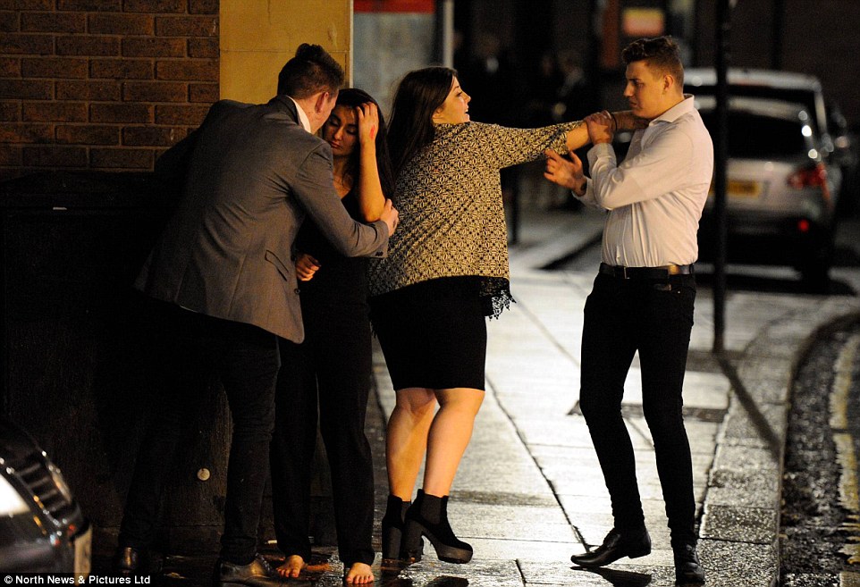 One without shoes: These four New Year's Eve revellers were pictured on the street in Newcastle last night
