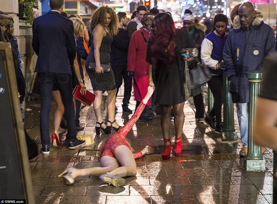 Requiring help: A woman lies on the pavement during New Year's Eve celebrations last night in central Birmingham