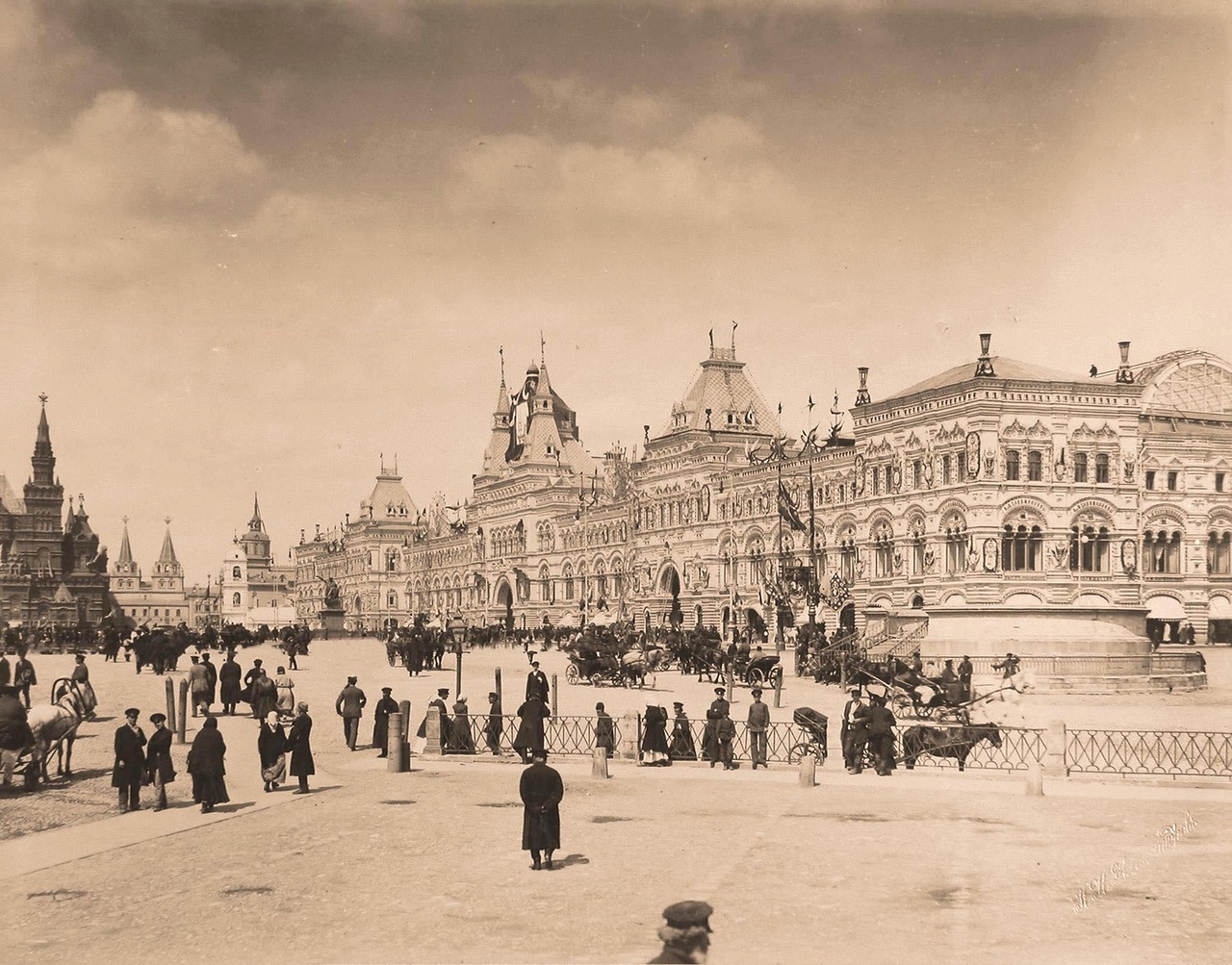 Горожане на Красной площади в дни коронационных торжеств; справа - Средние и Верхние торговые ряды; на втором плане - здание Исторического музея (слева), рядом (правее) - Воскресенские (Иверские) ворота. Горожане на Красной площади в дни коронационных торжеств; справа - Средние и Верхние торговые ряды; на втором плане - здание Исторического музея (слева), рядом (правее) - Воскресенские (Иверские) ворота.